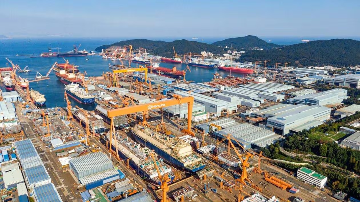 Vue aérienne d’un grand chantier naval sud-coréen, avec cales, navires et grues industrielles