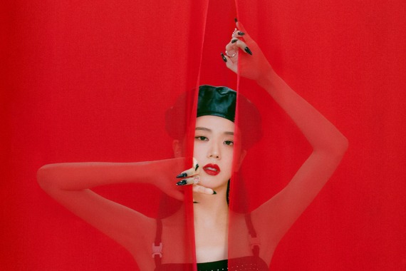 Portrait artistique de Jisoo sur fond rouge, derrière un voile translucide